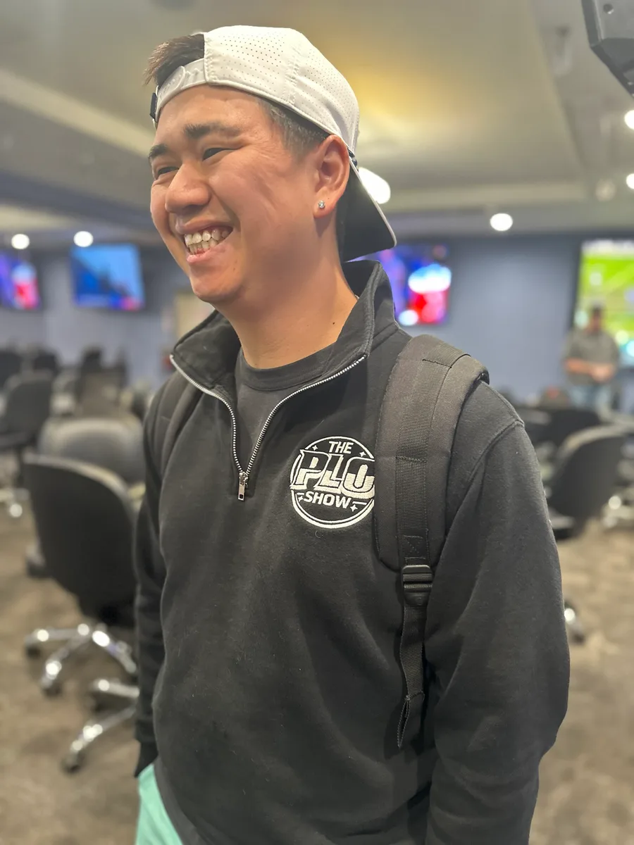 PLO Show fan laughing in the black quarter-zip at the poker room