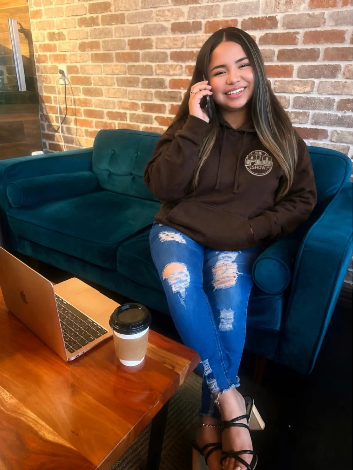 PLO Show fan in the brown hoodie at a coffee shop with her laptop