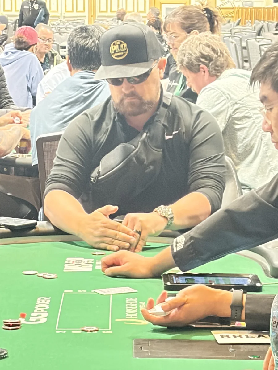 PLO Show player heads-down at the poker table reading the board